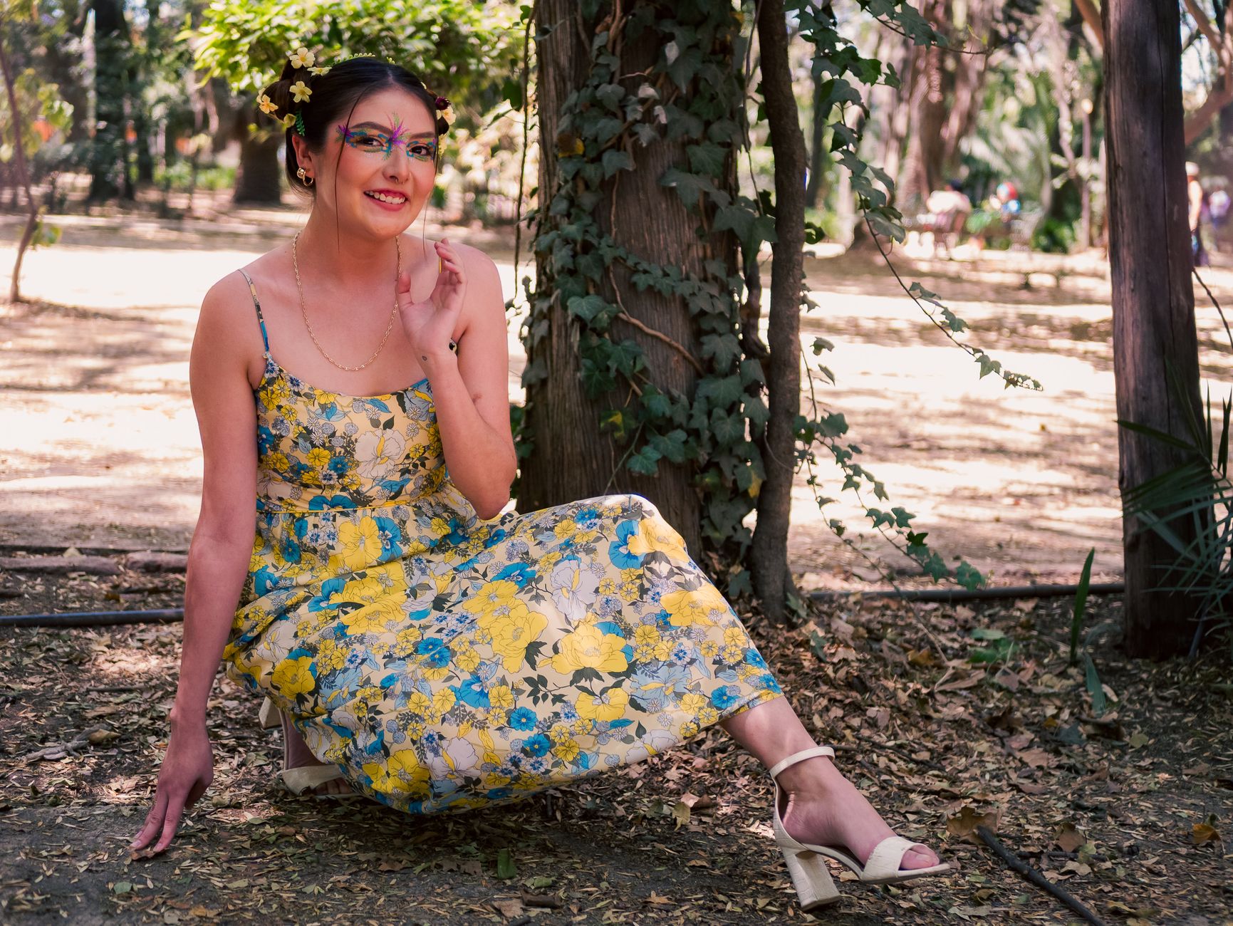 Smiling woman in floral dress enjoying a sunny day in a Mexico City park.