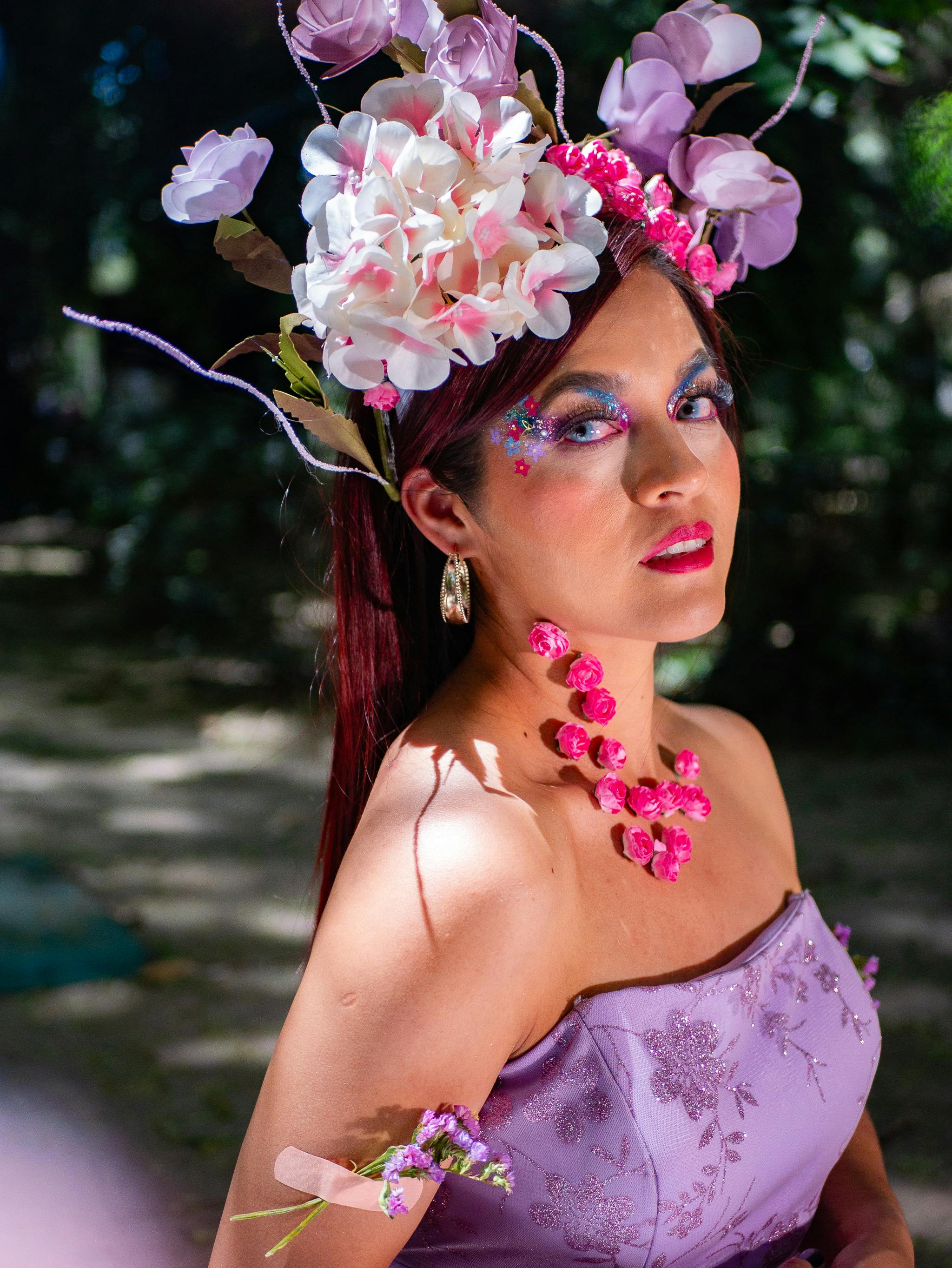 Woman with floral headpiece and makeup in a vibrant outdoor shoot.