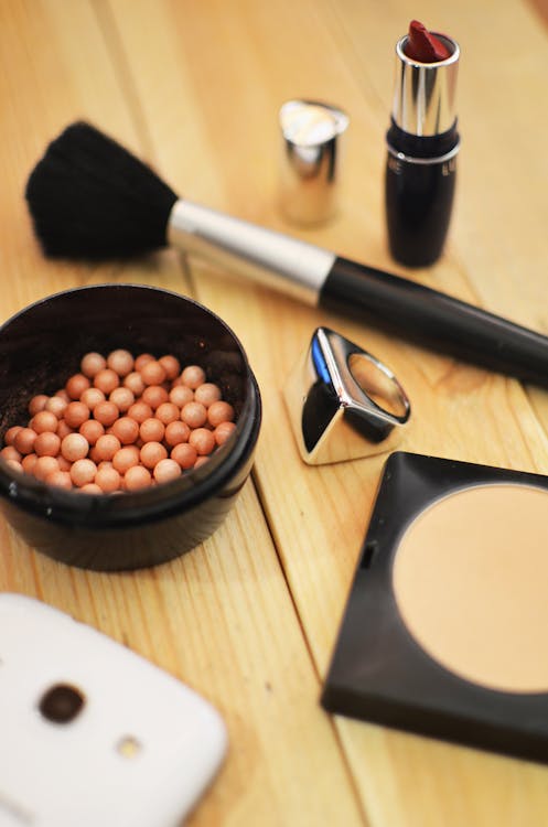 Black Makeup Brush Near Red Lipstick on Brown Wooden Surface