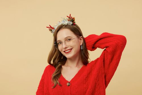 Free Smiling woman in red sweater and glasses wearing a festive headband. Stock Photo