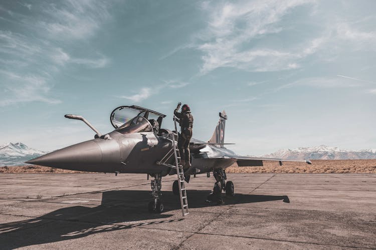 Photo Of Person Standing Beside Fighter Jet