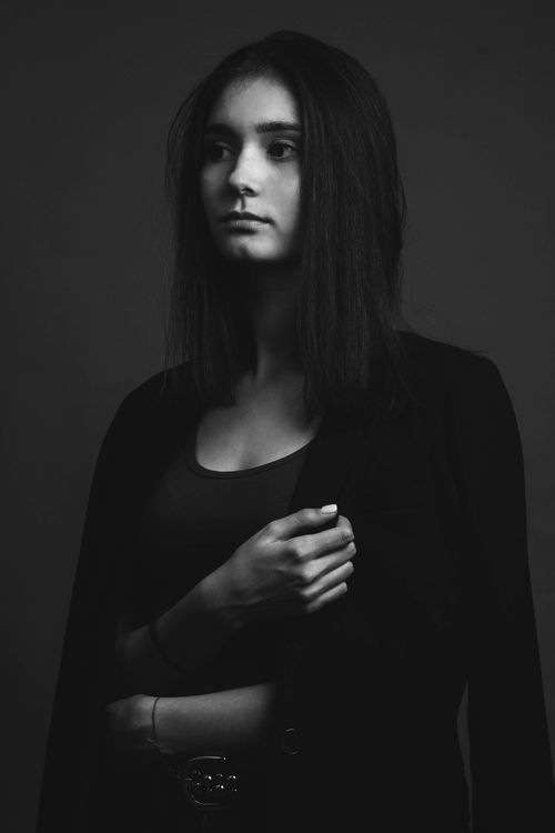 Free Stylish black and white portrait of a young woman in a thoughtful pose, showcasing modern fashion. Stock Photo