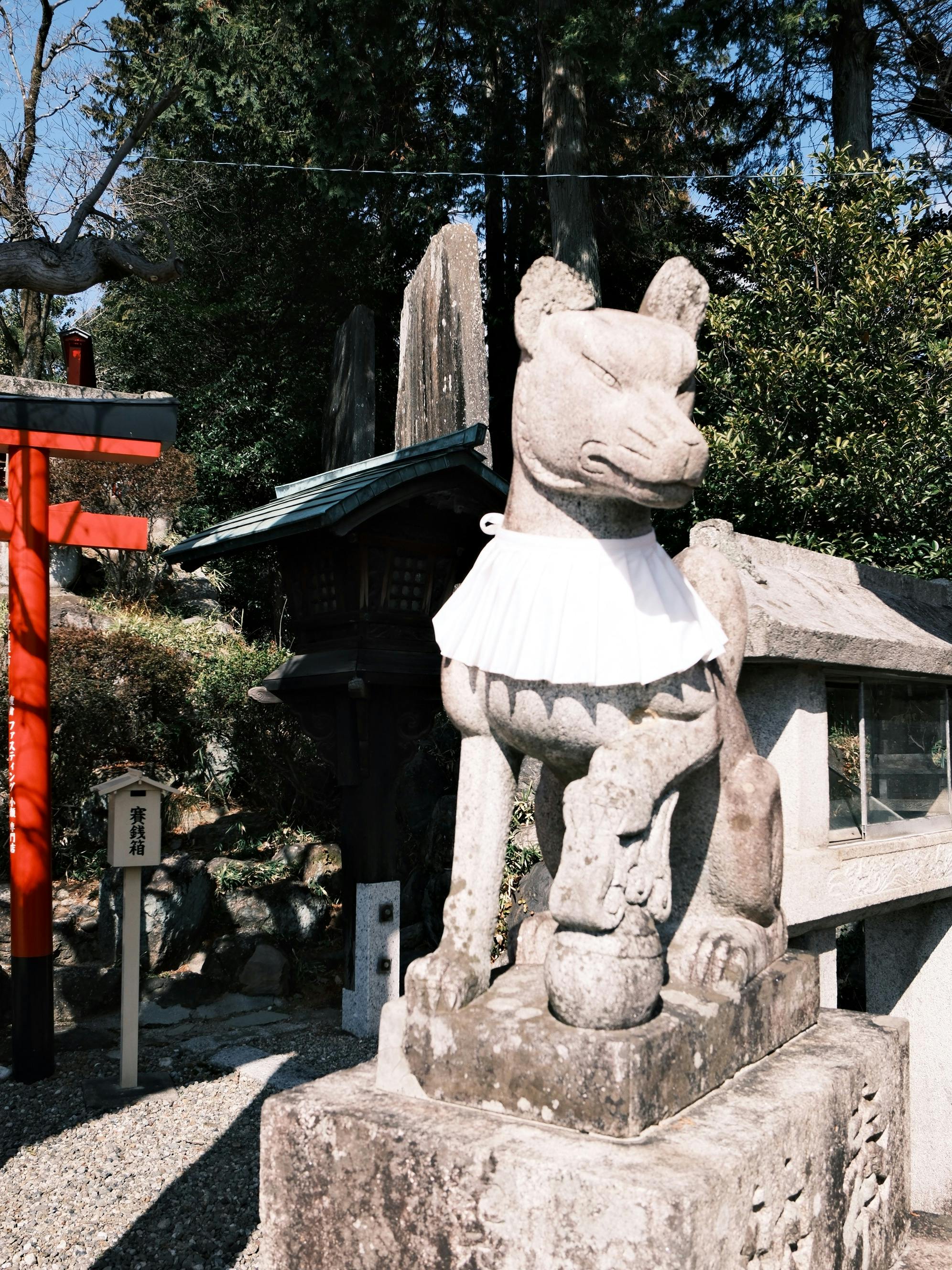 A traditional Komainu stone statue in a serene Nagoya shrine garden.