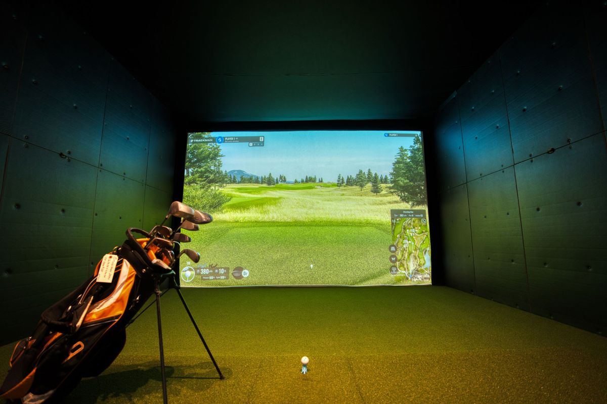 Golfsimulator hemma med slagduk och projicerad golfbana