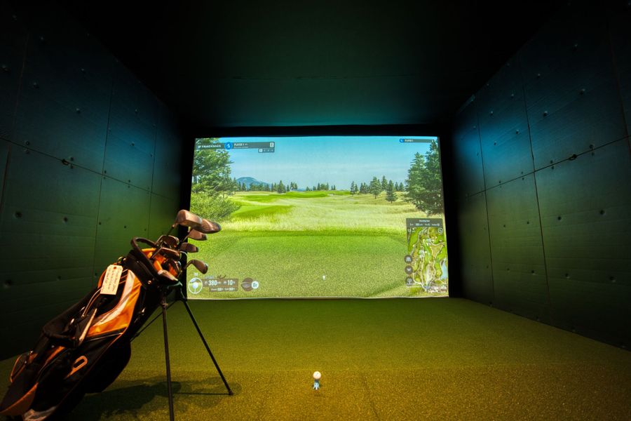 Modern indoor golf simulator bay with realistic course graphics