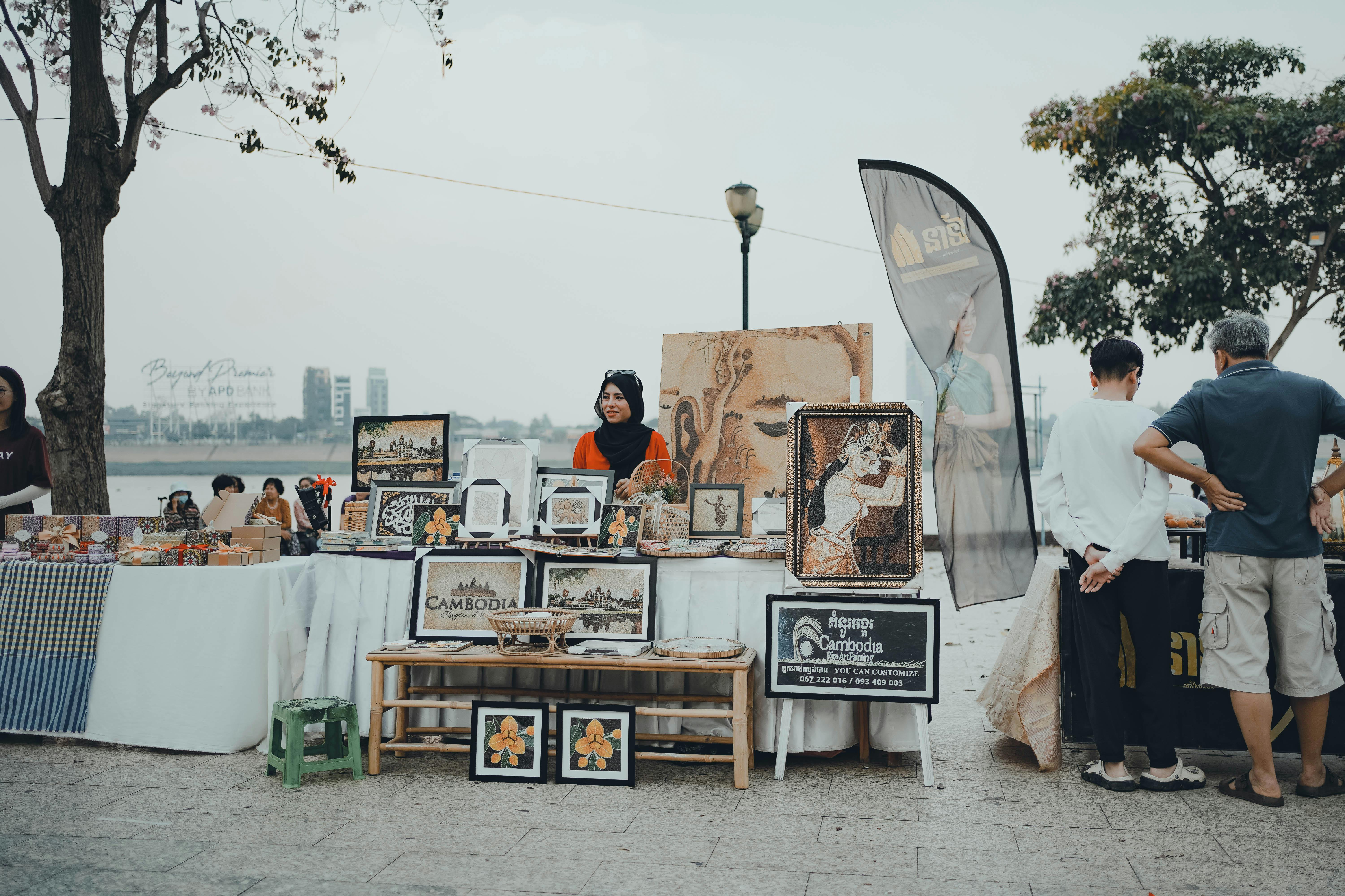 Manos sosteniendo un teléfono móvil en un mercado camboyano