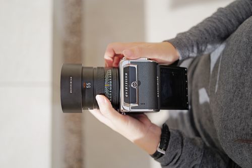 Free Close-up of hands holding a Hasselblad camera, capturing a vintage photography moment. Stock Photo