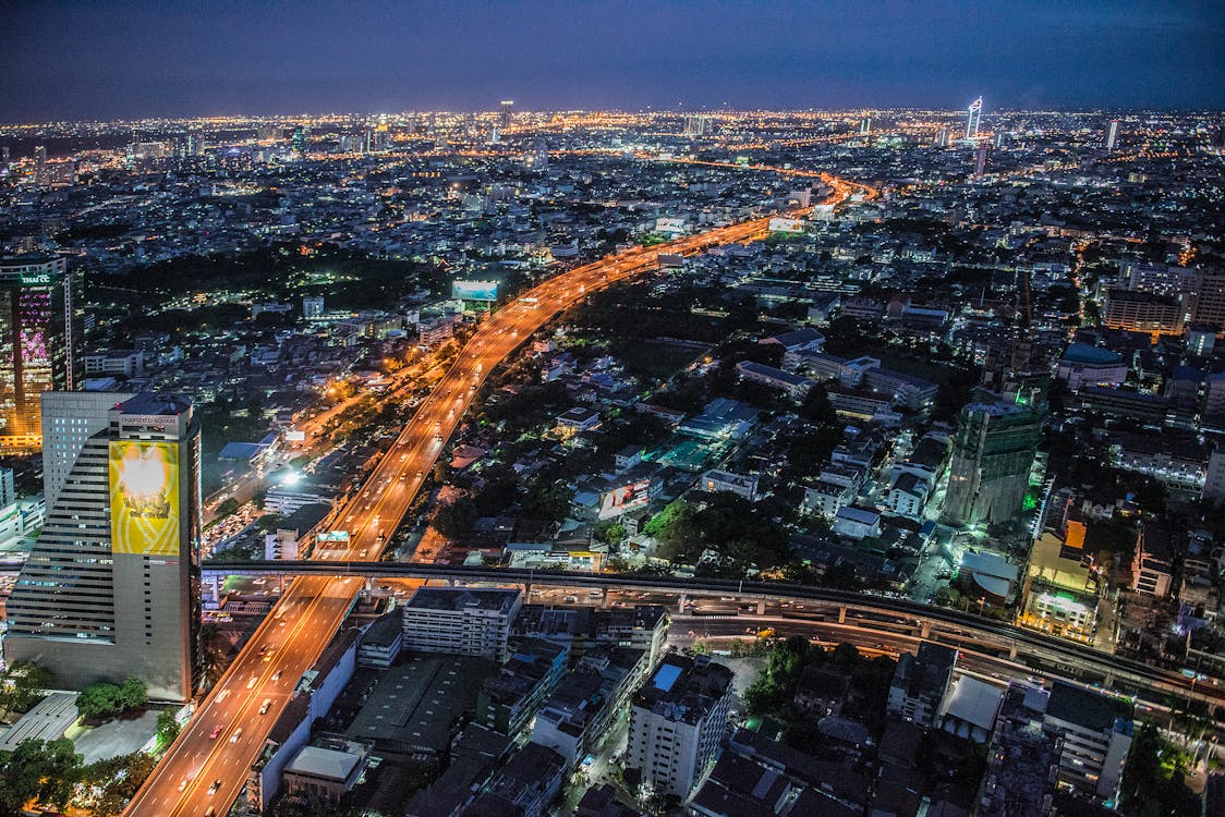 Aerial view of Bangkok at night, showcasing the illuminated skyline and bustling urban life.