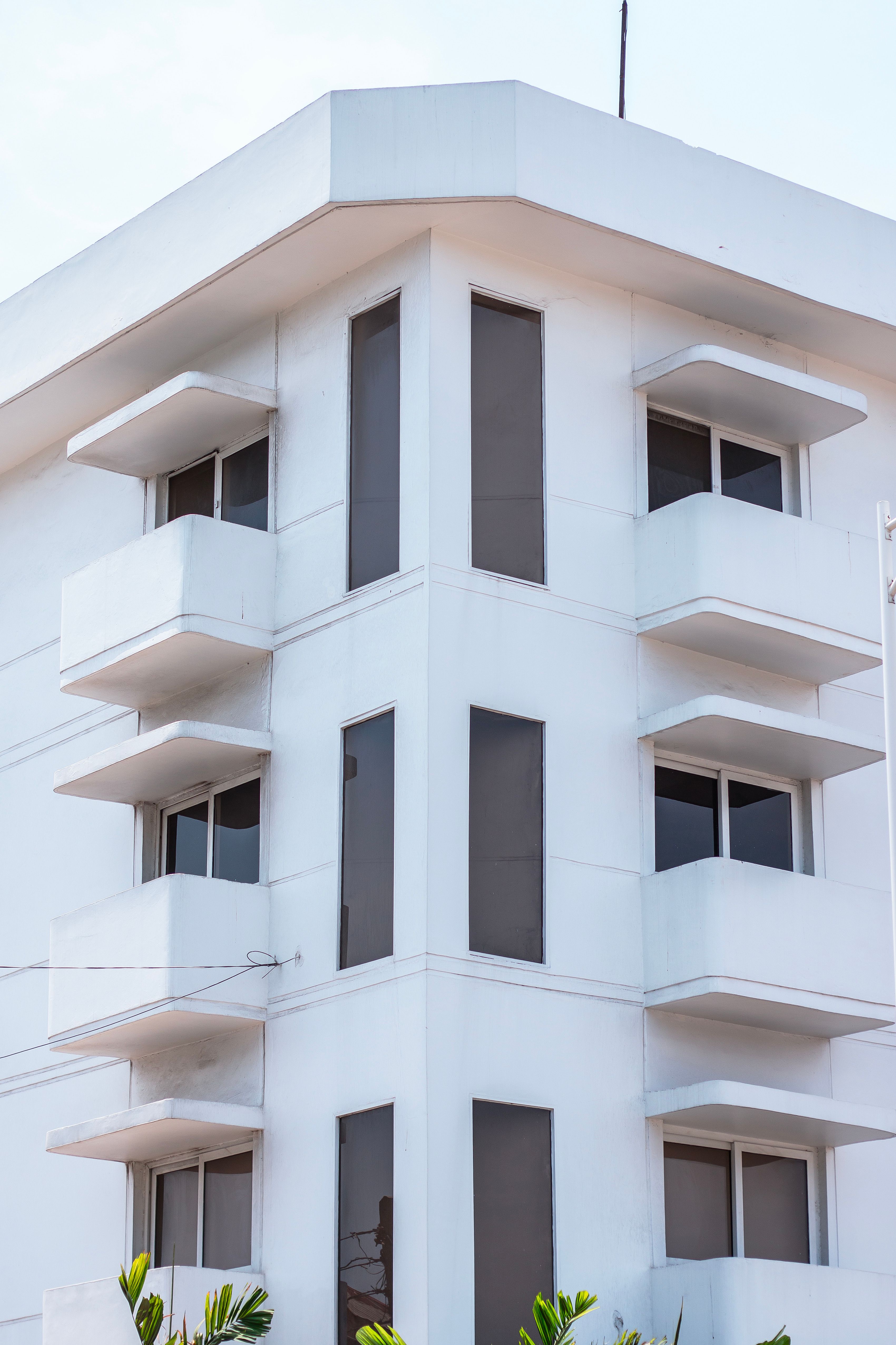 QBCC Open Builders Licence: Scope, Qualification & Experience 6 Modern white building with angular design and bal conies against a clear sky