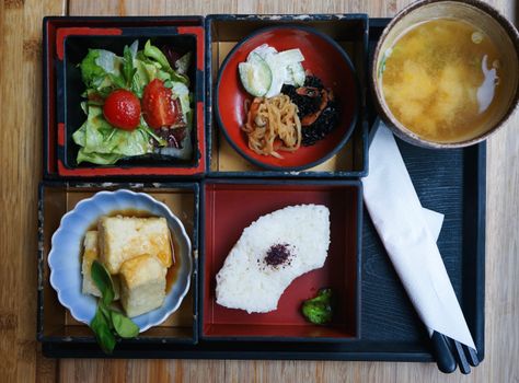 Delicious traditional Japanese bento box with various dishes including miso soup, served in Berlin, Germany.