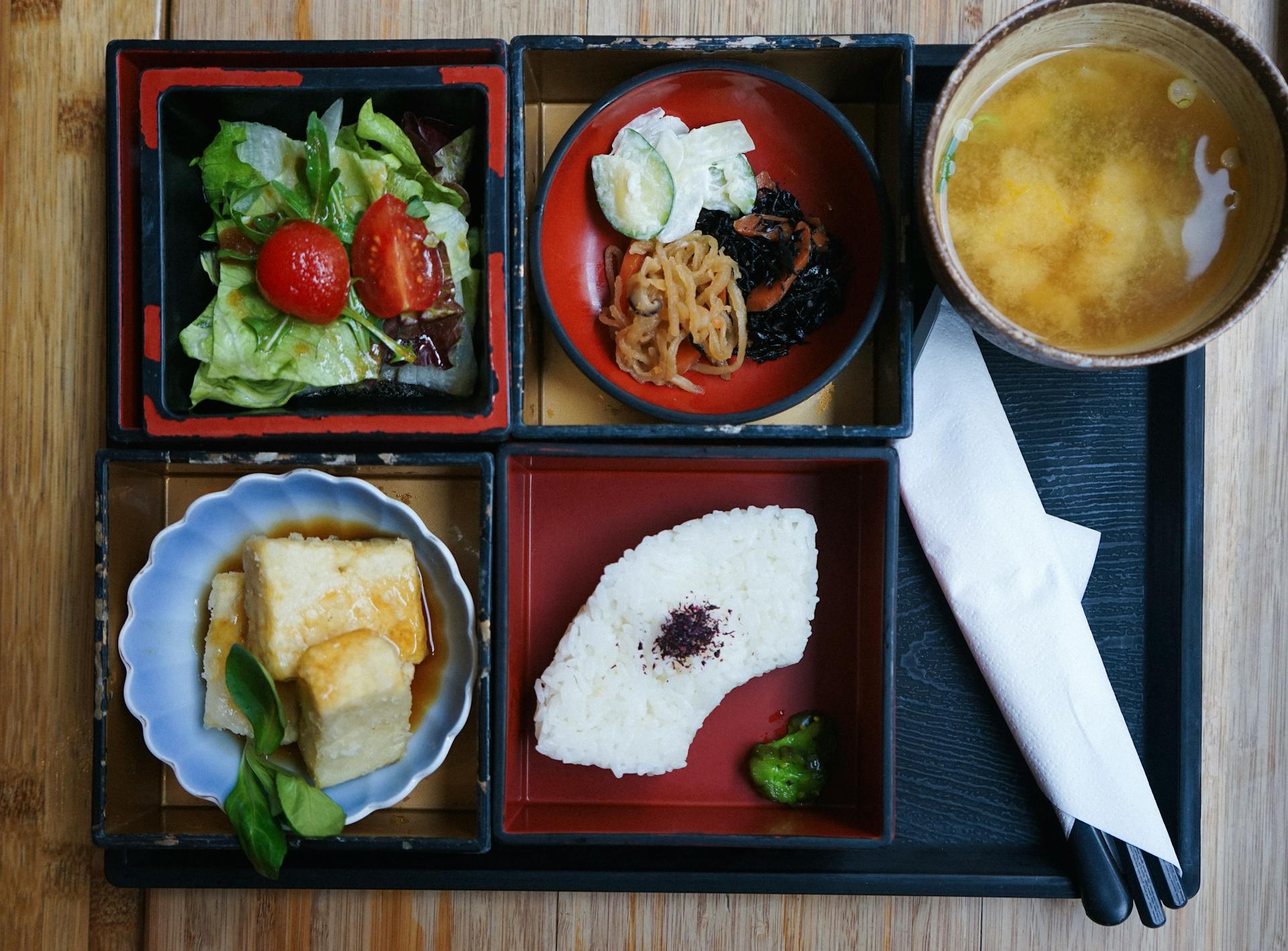 Delicious traditional Japanese bento box with various dishes including miso soup, served in Berlin, Germany.