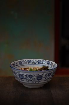 Savor authentic Chinese noodle soup served in a classic blue and white patterned bowl in Penang, Malaysia.