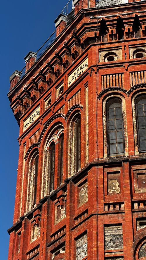 Free A stunning view of a red brick building with classical architecture against a clear blue sky. Stock Photo