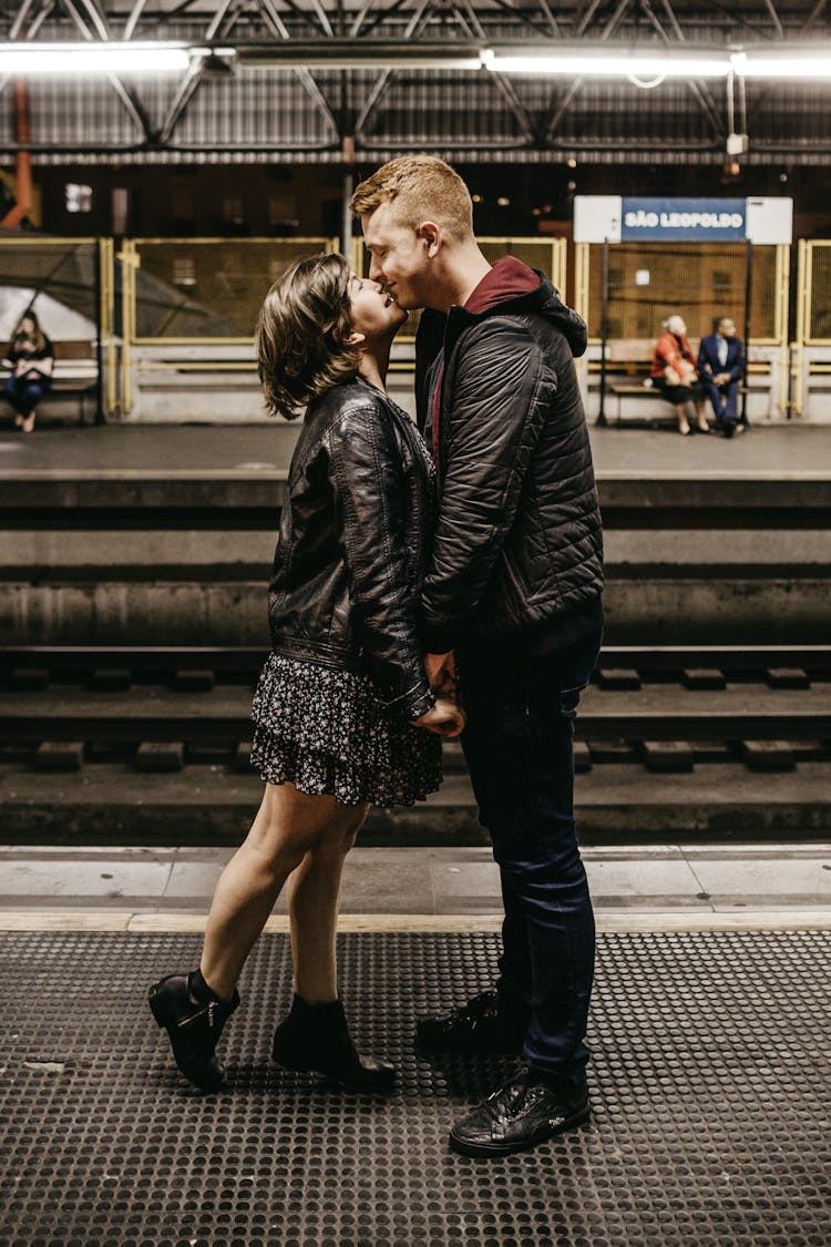 Photo Of Couple Kissing While Standing On Train Station Platform