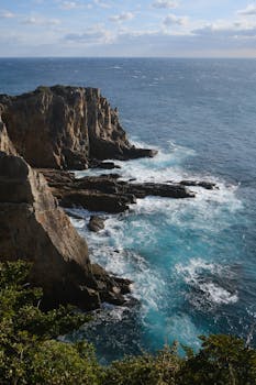 Stunning view of scenic cliffs and crashing waves along Wakayama's coastline in Japan.