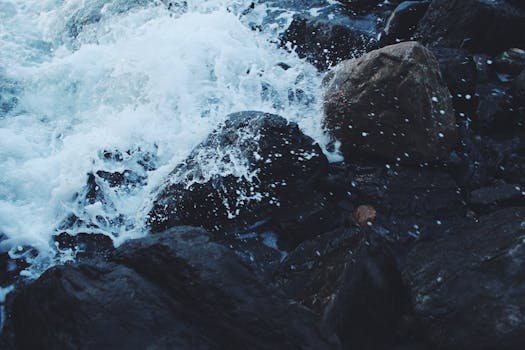 汹涌的海浪拍打着黑暗的岩石海岸，捕捉自然的律动