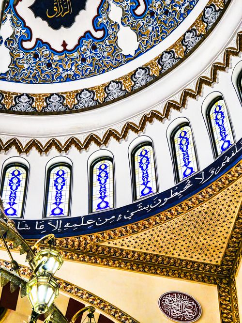 Free Detailed view of an ornate mosque dome with Islamic calligraphy and intricate patterns in Dubai. Stock Photo