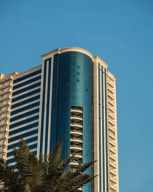 Free A striking modern skyscraper in Dubai with clear blue skies, showcasing urban architecture. Stock Photo