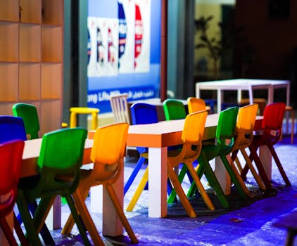 Vibrant plastic chairs around tables at an outdoor cafe in Dubai.