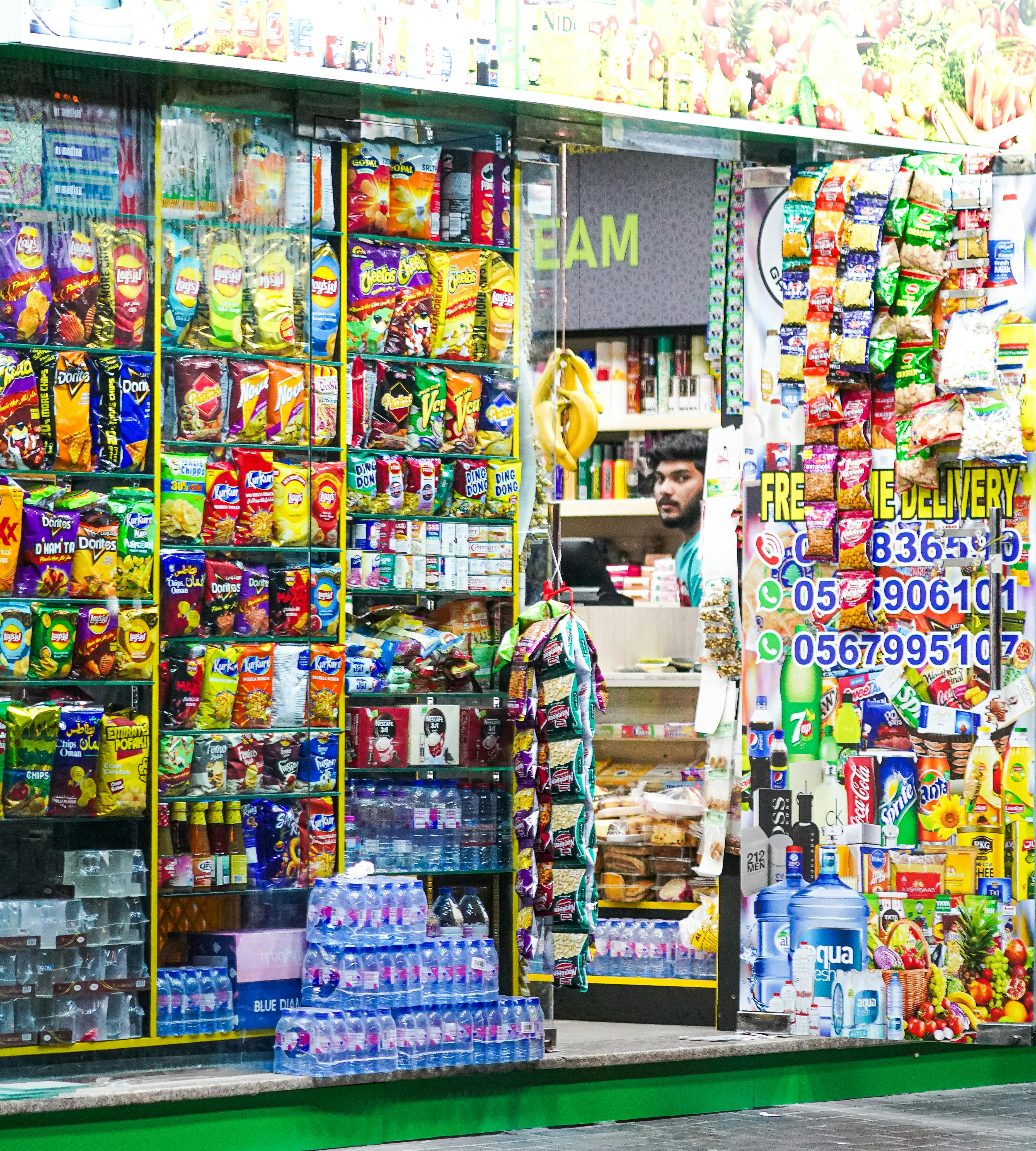 A colorful display of snacks and goods at a bustling Dubai corner store.