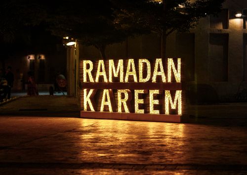 Free A shimmering Ramadan Kareem sign lights up a Dubai street at night, capturing the festive ambiance. Stock Photo