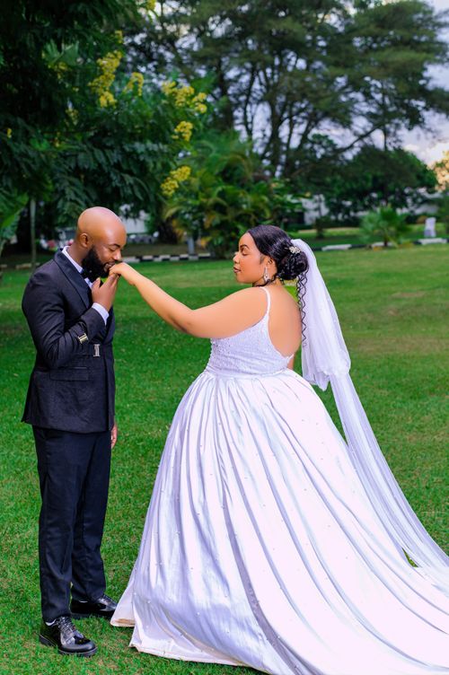 Free Bride and groom share a tender moment in a lush garden setting. Stock Photo