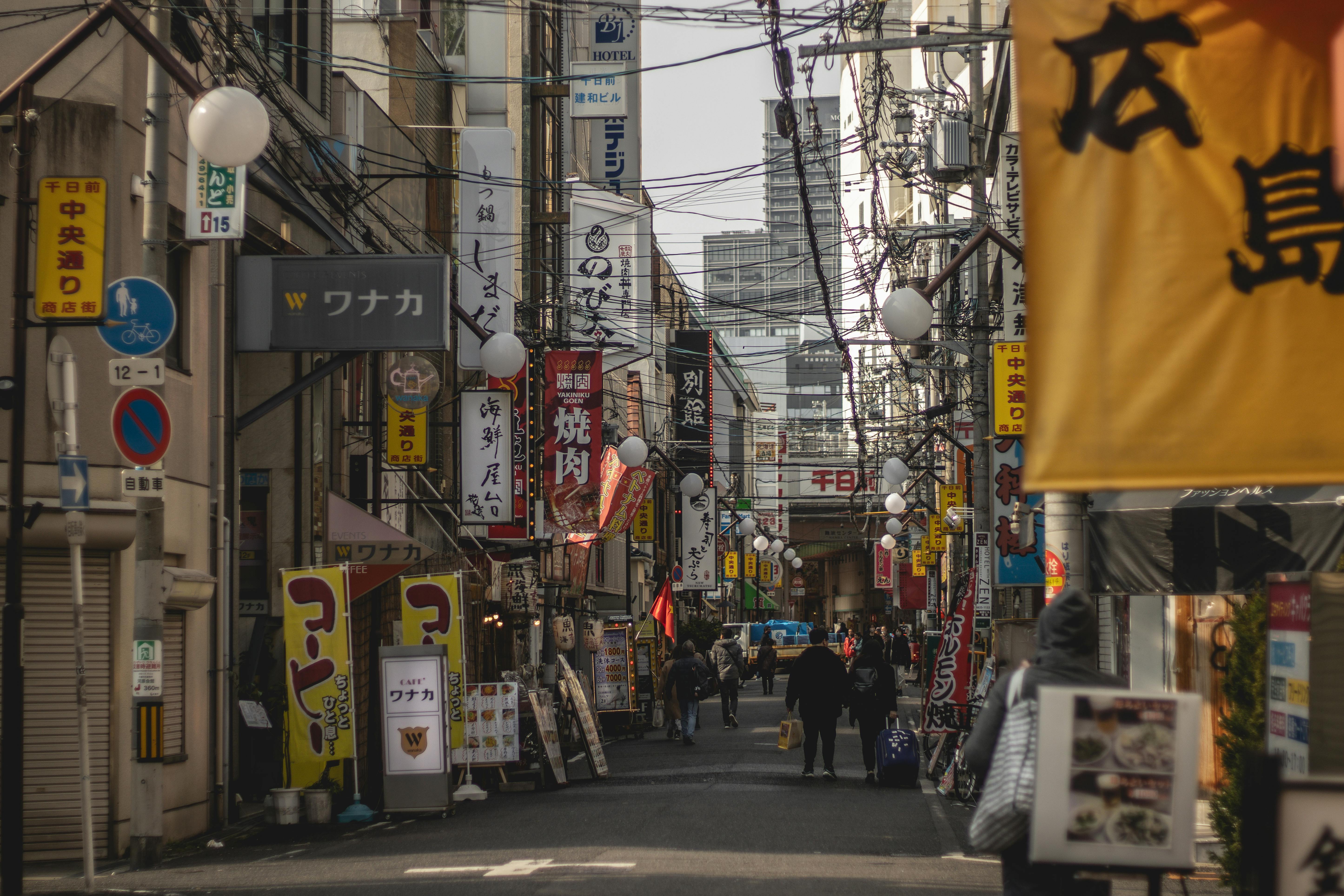伝統的な日本の看板と賑やかな雰囲気が漂う、大阪難波地区の繁華街。