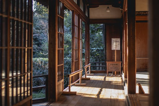 A serene view of a sunlit traditional Japanese tea house interior with wooden architecture.