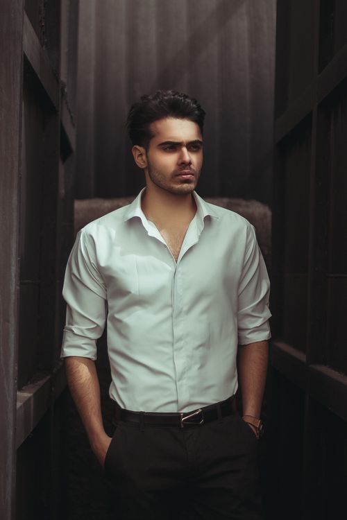 Free Portrait of a confident man in a white shirt standing in an urban environment in Kermanshah, Iran. Stock Photo