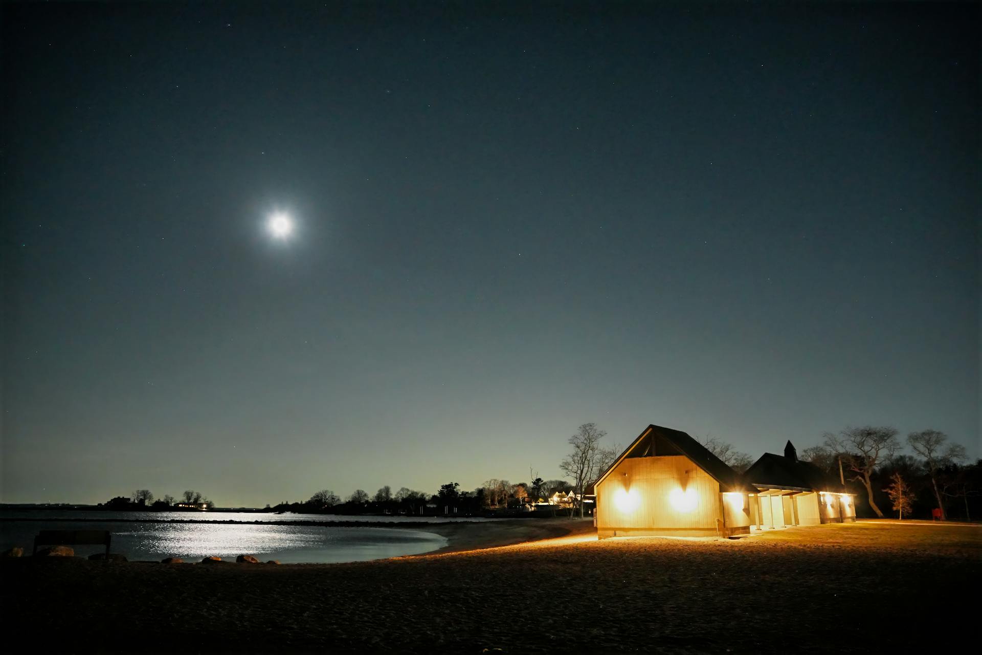 A serene moonlit scene at Cove Island Park with a bright moon over still waters.