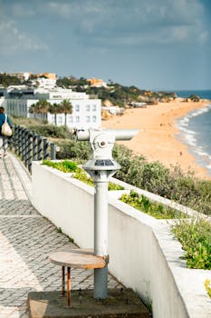 Explore a beautiful beachfront with a telescope overlooking a sunny bay in Portugal.