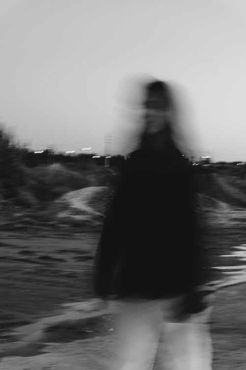 Free Black and white photo of a blurred person outdoors at dusk, creating an artistic and moody ambiance. Stock Photo