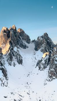 Breathtaking view of snow-covered Dolomites in Veneto, Italy with alpine glow at sunset.