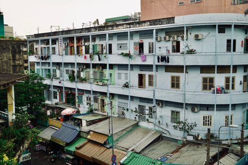 Free A street-level view of a multi-story apartment building with visible laundry and air conditioners. Stock Photo