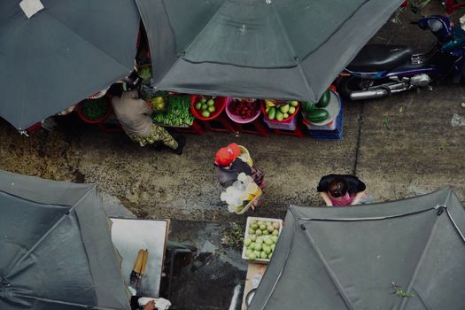 Top view of an outdoor market with vendors and colorful produce, showcasing vibrant street life.
