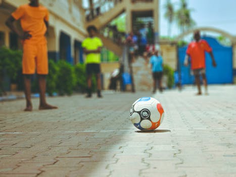 A vibrant street soccer scene with diverse players and a focus on a soccer ball.