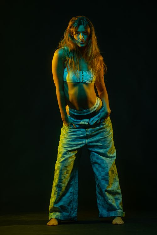 Free Studio portrait of a woman in bold lighting and fashion-forward attire. Stock Photo