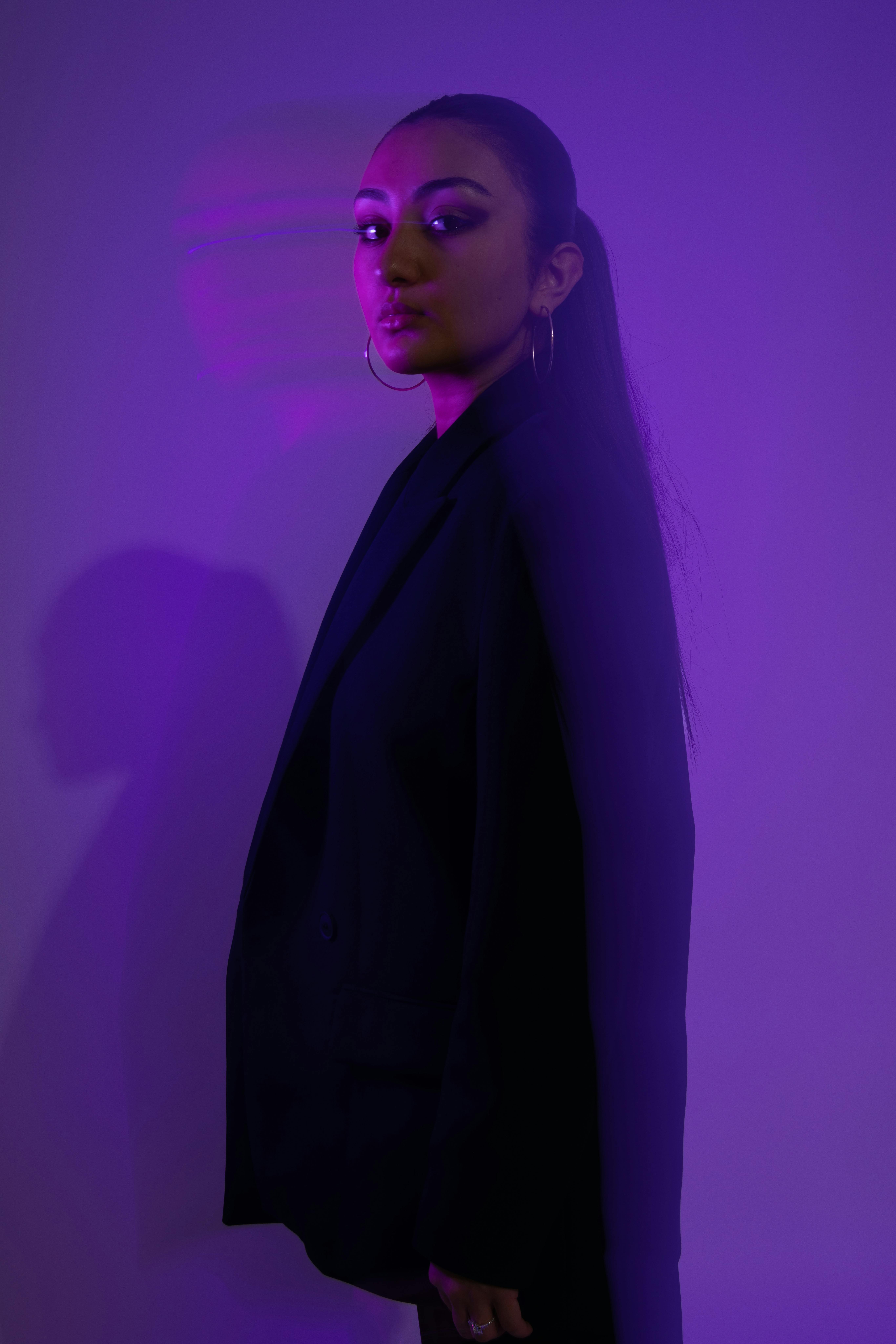 Fashionable portrait of a woman in purple lighting, featuring bold and modern aesthetics.
