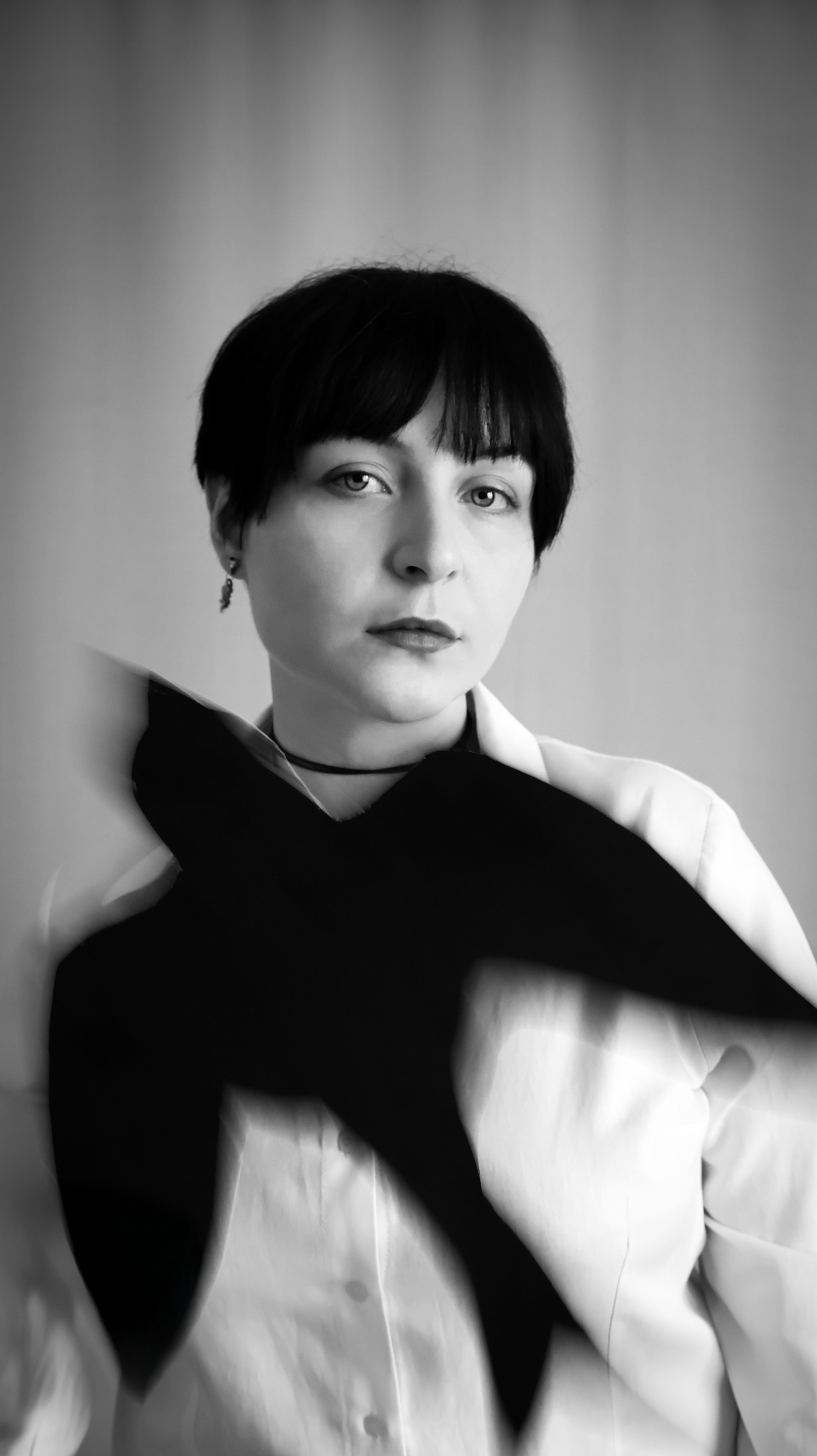 Black and white artistic portrait featuring a person and blurred bird silhouette.