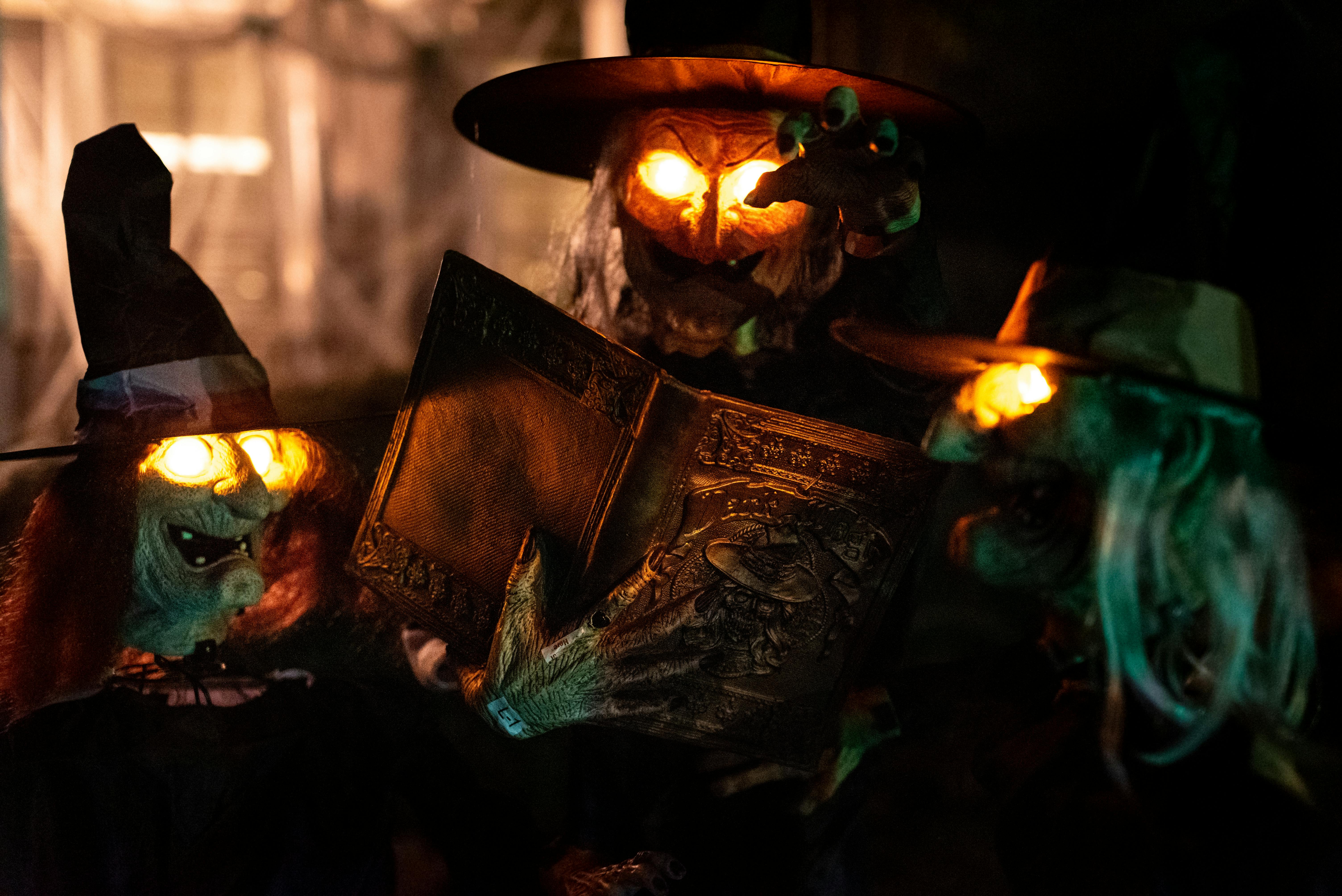 Halloween decorations featuring glowing witch figures and an eerie book in Atlanta, Georgia.