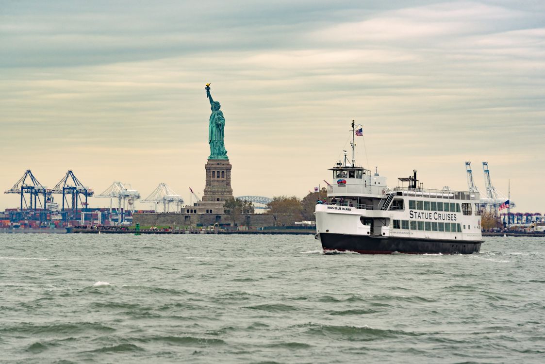 Ferry Passing Statue Of Liberty In New York Harbor Free Stock Photo ferry-passing-statue-of-liberty-in-new-york-harbor-free-stock-photo