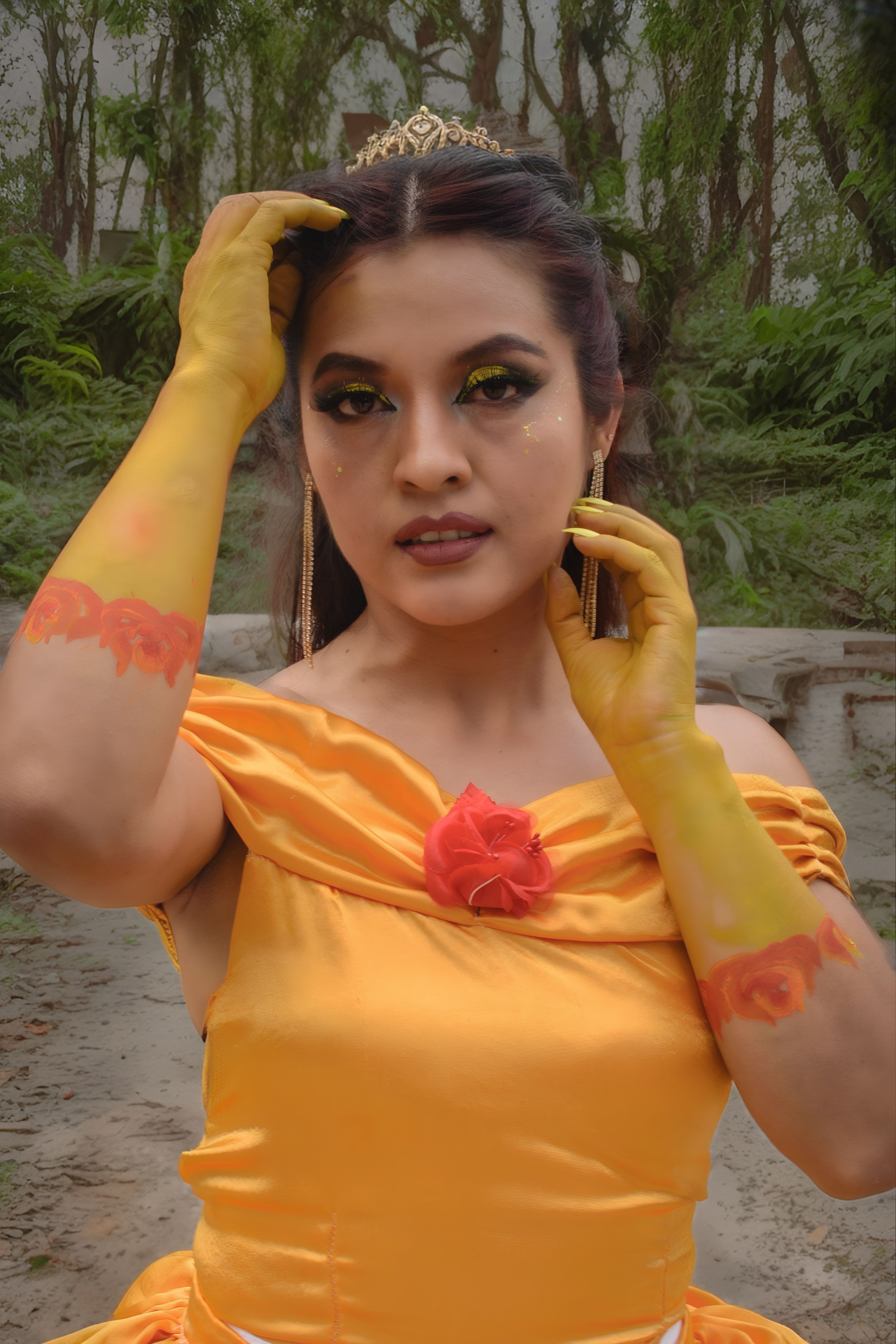 Elegant woman in yellow dress with floral makeup posing outdoors.