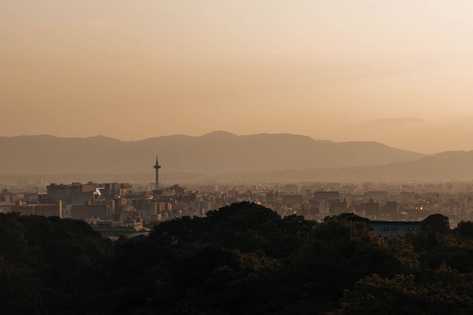 夕暮れ時の京都タワーと周囲の山々を背景にした京都の街並みの息を呑むような眺め。