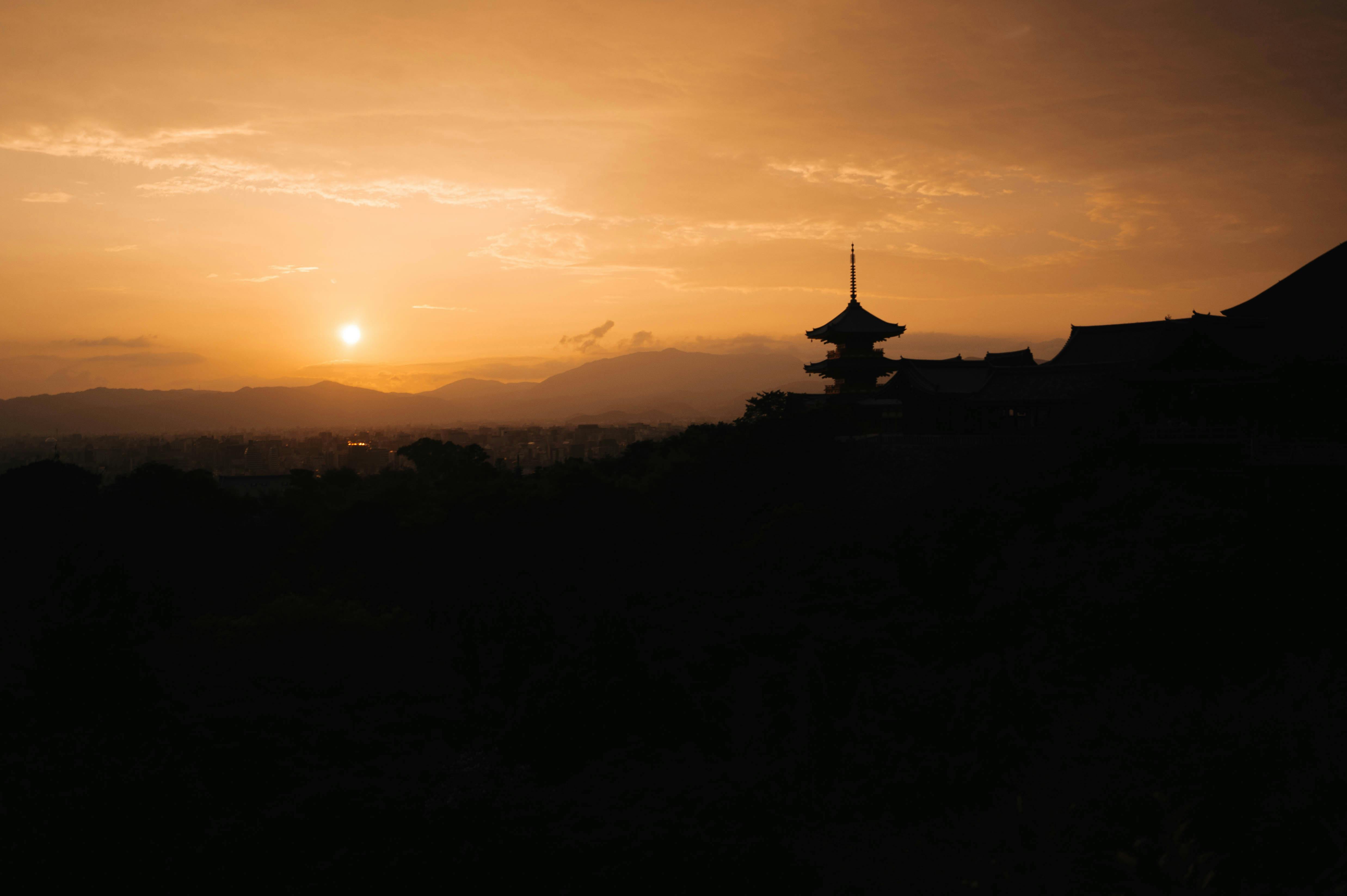 A captivating view of a Kyoto temple silhouette against a stunning sunset.