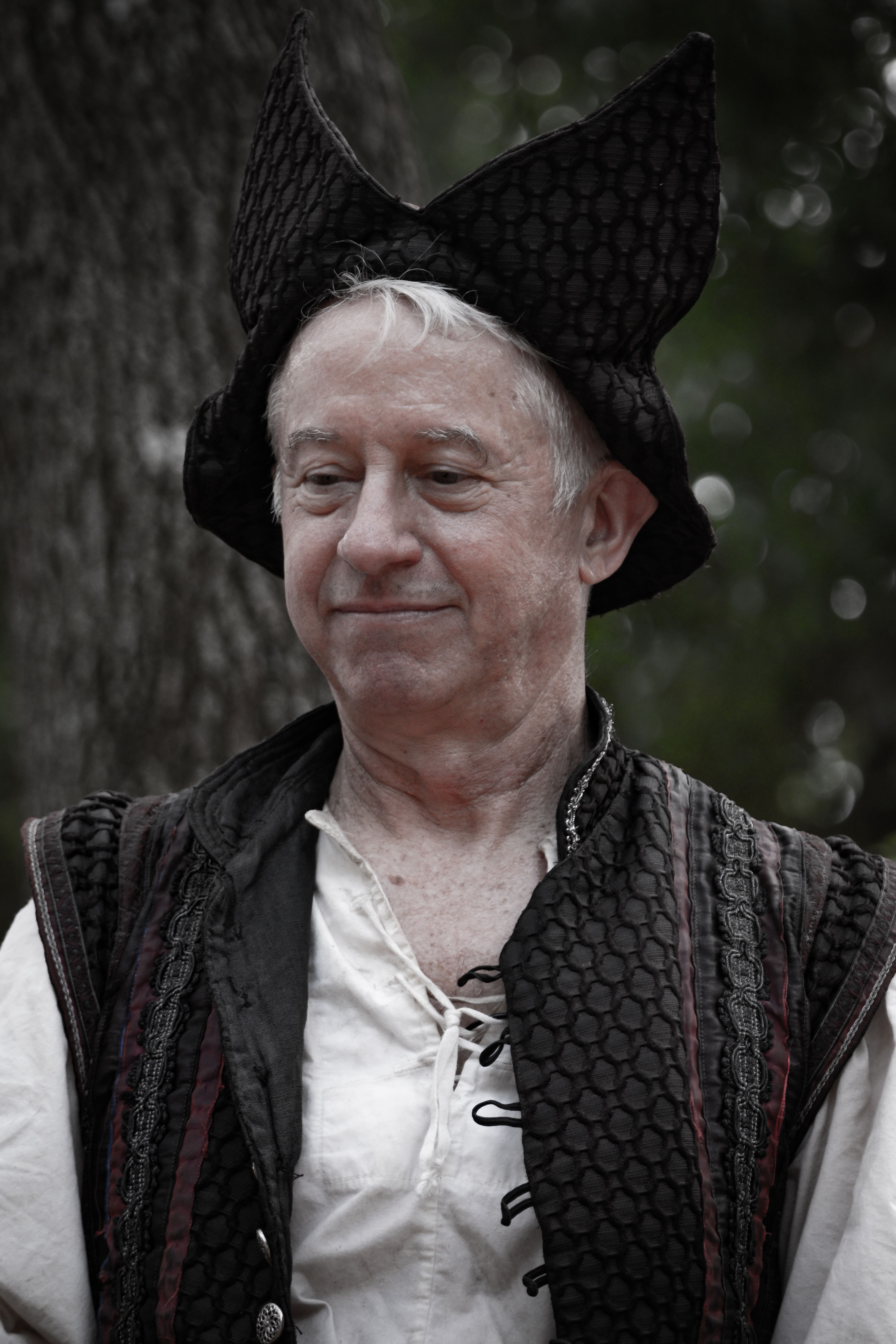 A senior man in Renaissance costume during an outdoor festival.
