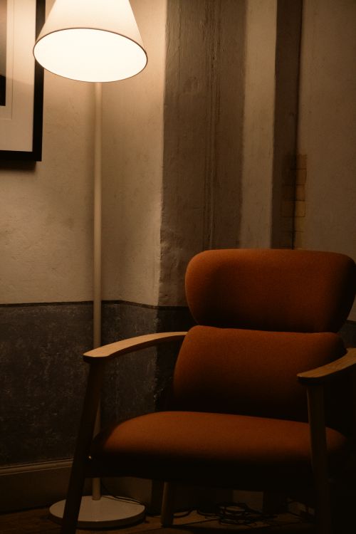 Free A warm and inviting corner featuring a lamp and an armchair, perfect for relaxation. Stock Photo