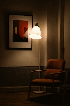 A warm, inviting corner featuring a modern armchair, floor lamp, and abstract art.