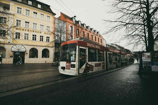 A tram passes through a historic street in Würzburg, Bavaria, Germany.