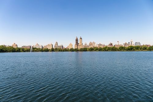 Free Breathtaking view of NYC skyline across Central Park reservoir on a sunny day. Stock Photo
