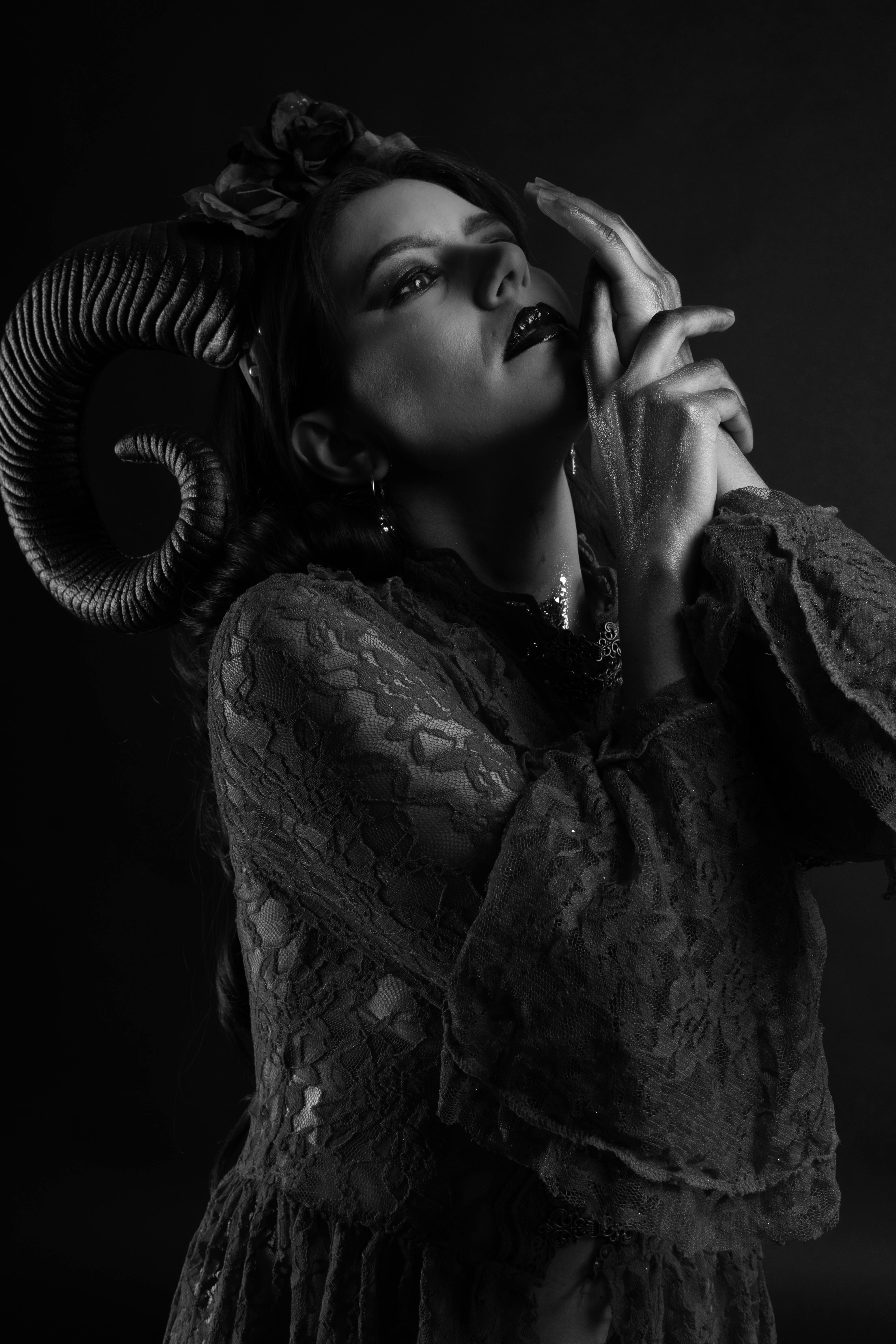 Gratuit Portrait artistique en noir et blanc d'une femme portant des cornes de bélier dans un décor sombre et maussade. Photos
